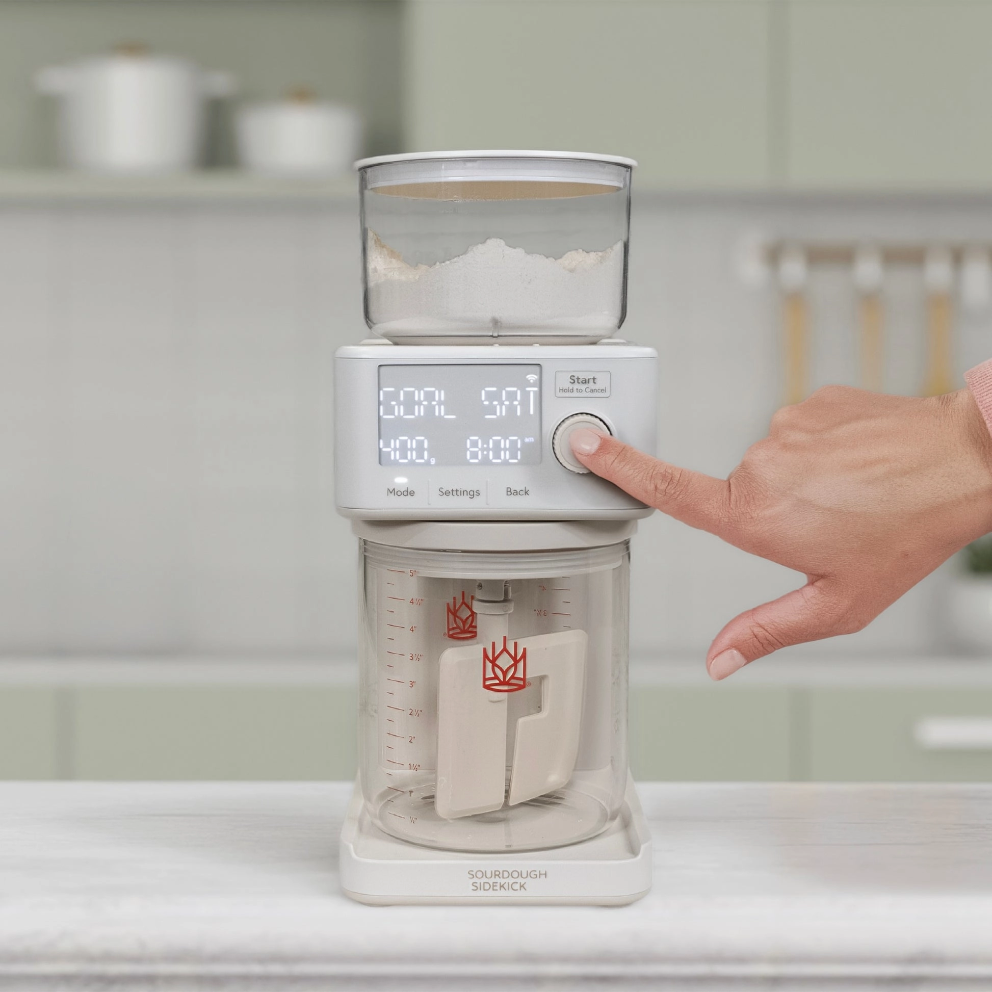 A person selecting a mode for the Sourdough Sidekick in a kitchen