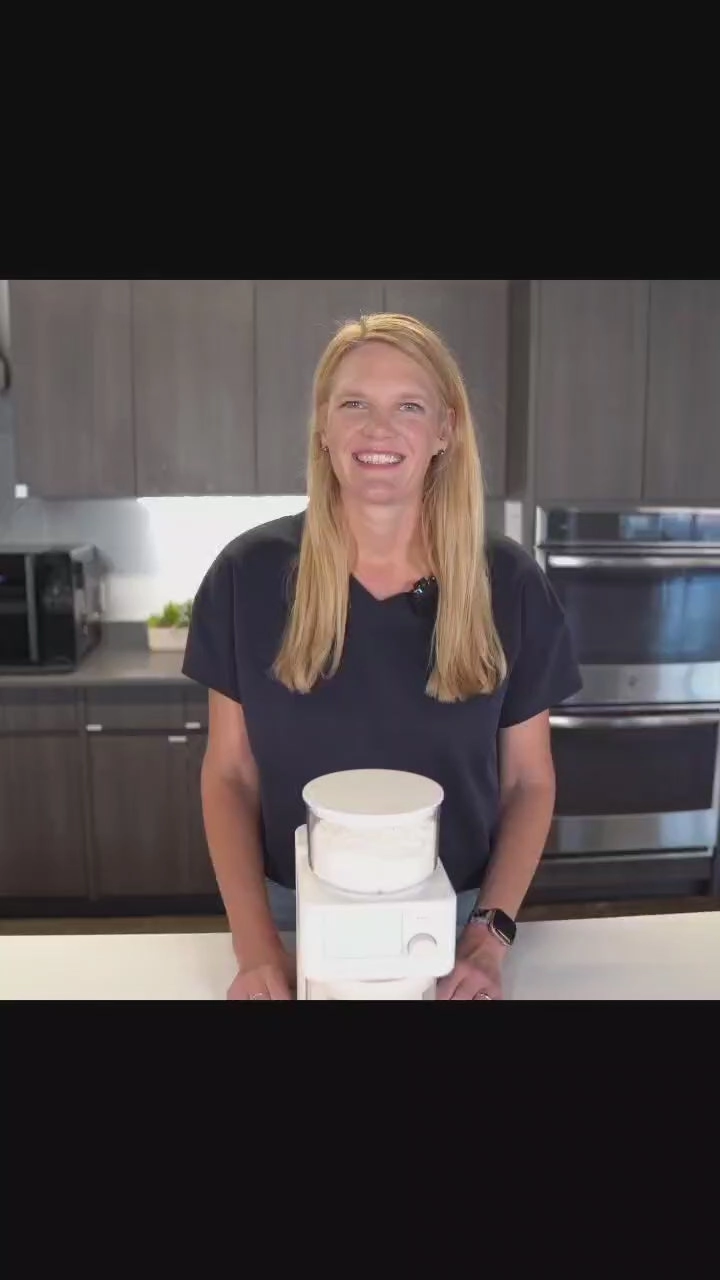 A baker in her kitchen holding the Sourdough Sidekick crock