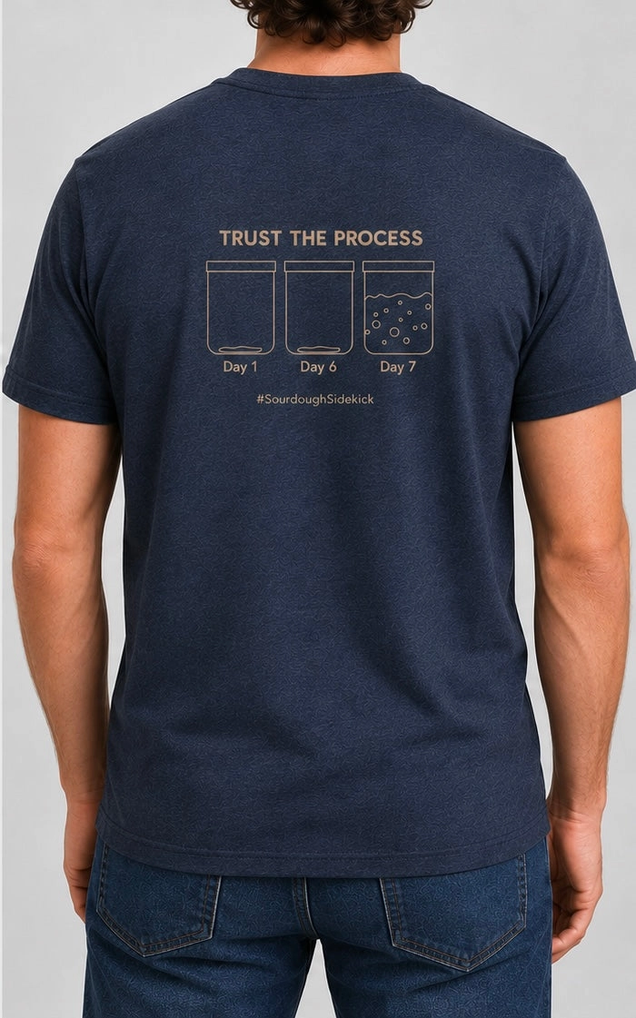 Person wearing a navy blue t-shirt with a Trust the Process graphic on the back